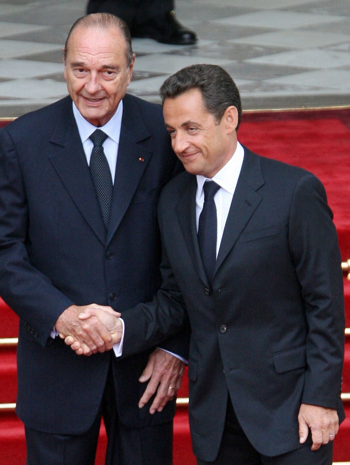 French president Jacques Chirac (L) welcomes his successor Nicolas Sarkozy upon his arrival at the Elysee Palace for the formal handover of power ceremony, 16 May 2007 in Paris