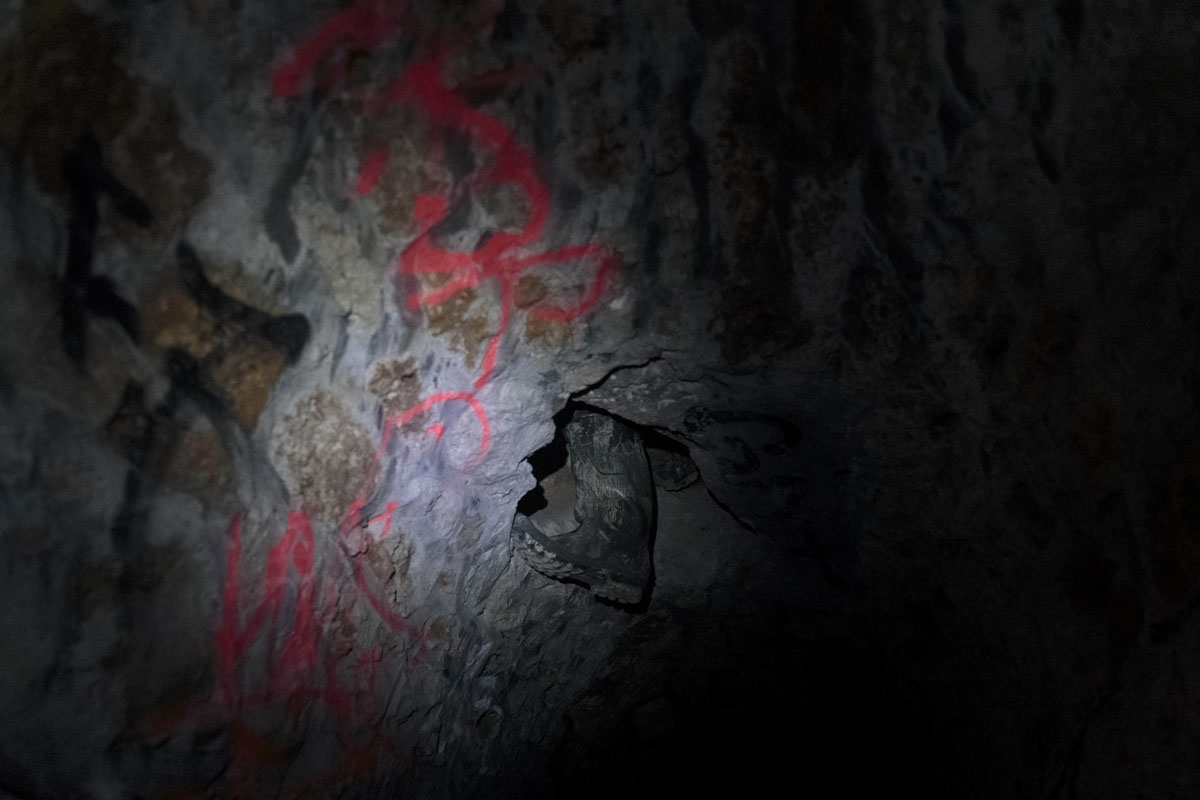In this photograph taken on October 31, 2017, a person passes through a chatiere as they enter the banned catacombs of Paris.