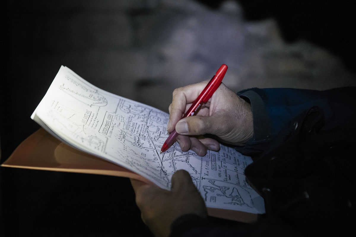 This photograph taken on October 31, 2017, shows a person looking at a map in the banned catacombs of Paris.