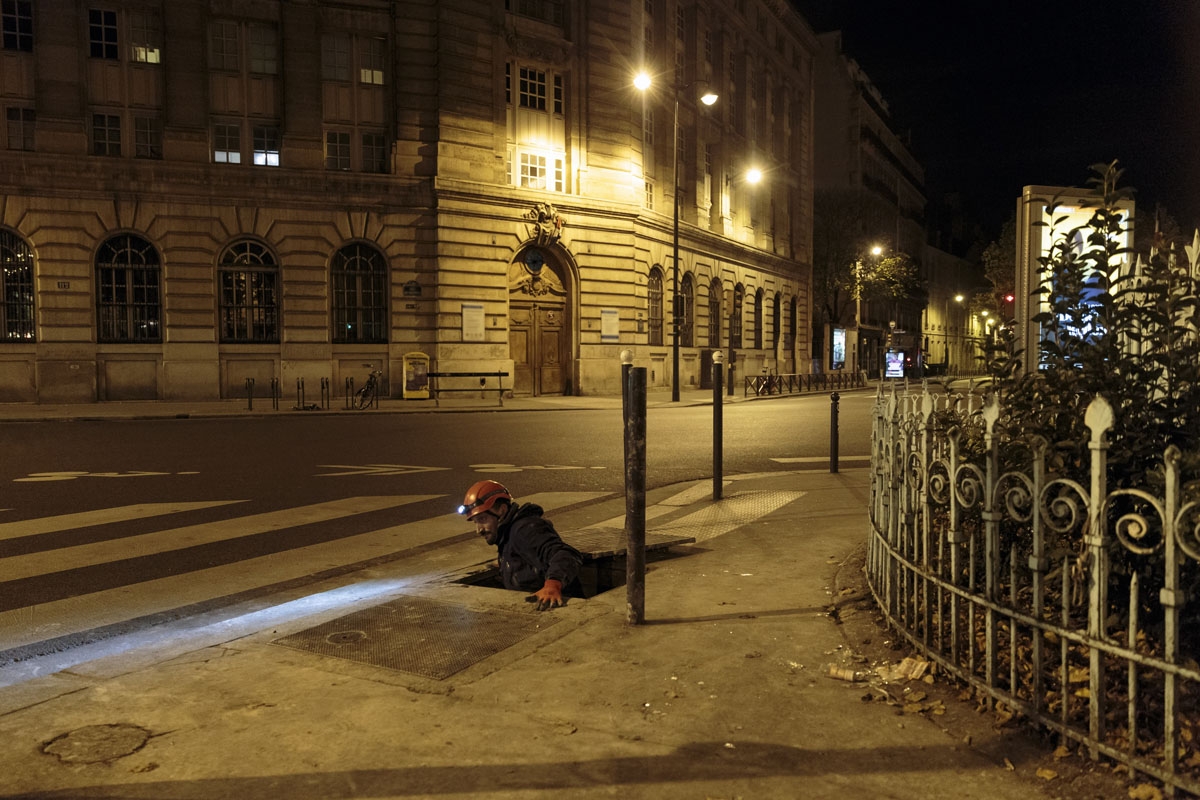 In this photograph taken on October 31, 2017, Pascal, 36, manouvers himself through an opening as he exits the banned catacombs of Paris.