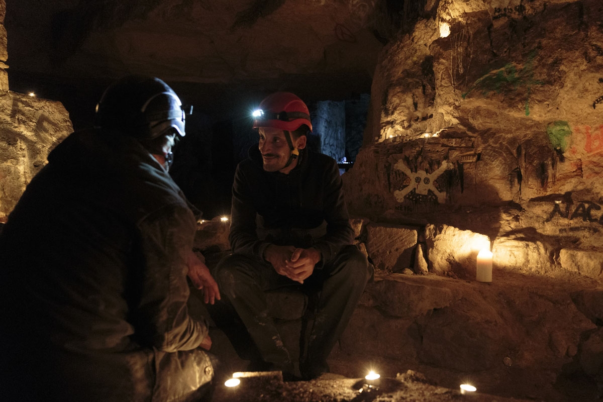 This photograph taken on November 7, 2017, shows cataphiles as they talk in the Z room in the banned catacombs of Paris.