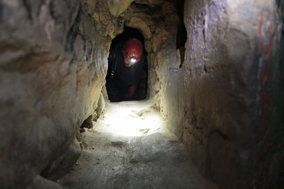 In this photograph taken on November 7, 2017, Pascal 36, crawls in a chatiere in the banned catacombs of Paris.