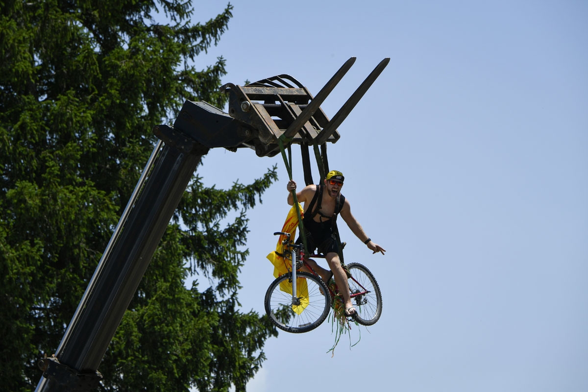 A supporter sits on a bike suspended from a crane along the road during the 187,5 km eighth stage of the 104th edition of the Tour de France cycling race on July 8, 2017 between Dole and Station des Rousses.