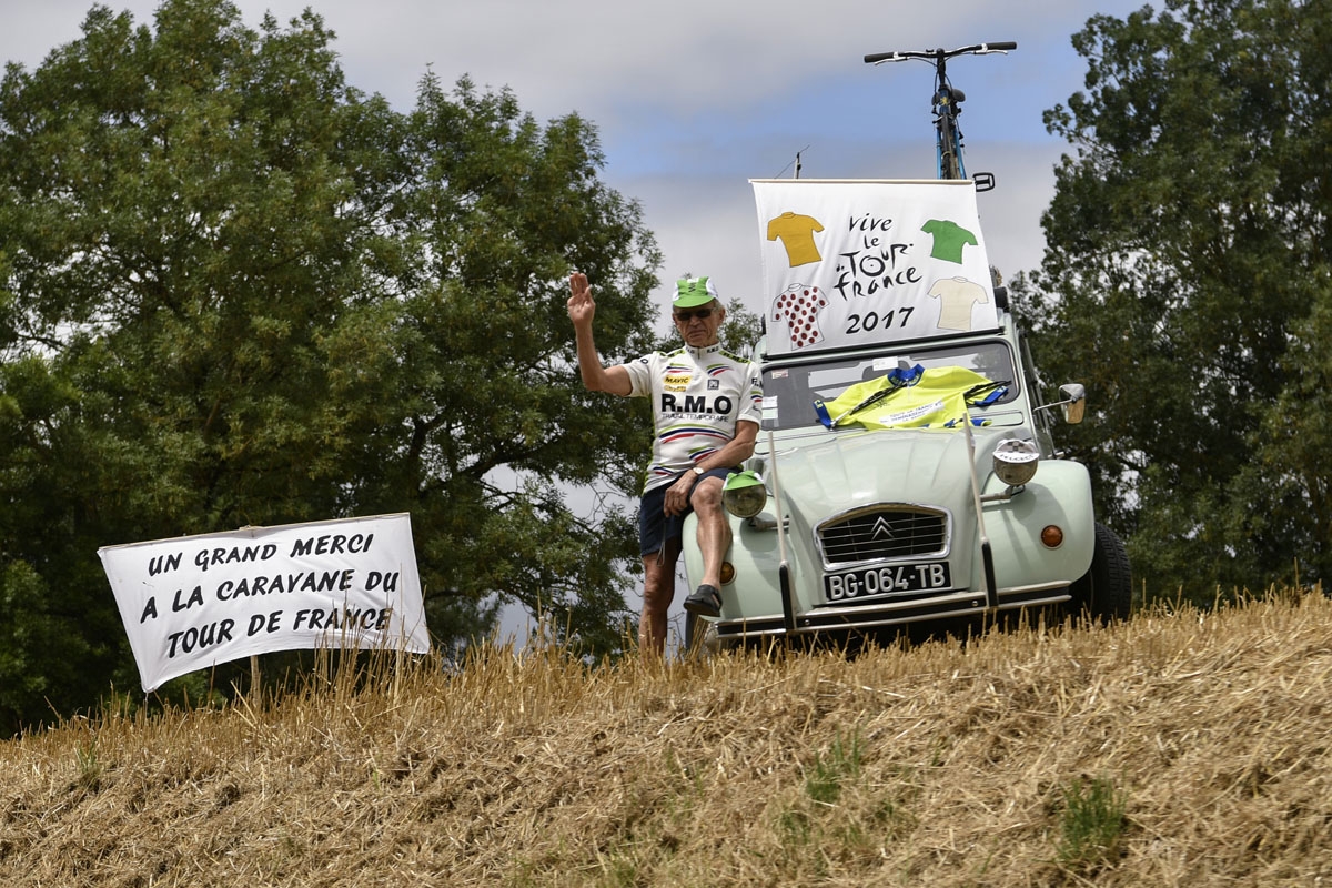 A supporter cheers along the road near placards reading A big thank you to the caravan of the Tour de France (L) and Long life the Tour de France during the 203,5 km eleventh stage of the 104th edition of the Tour de France cycling race on July 12, 2017 b