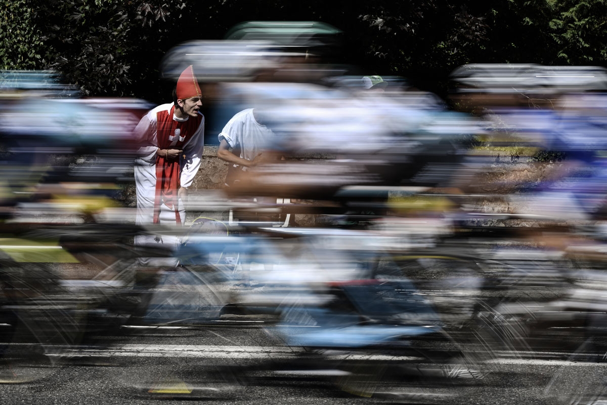 A supporter disguised as a priest cheers as the pack rides during the 181,5 km fourteenth stage of the 104th edition of the Tour de France cycling race on July 15, 2017 between Blagnac and Rodez