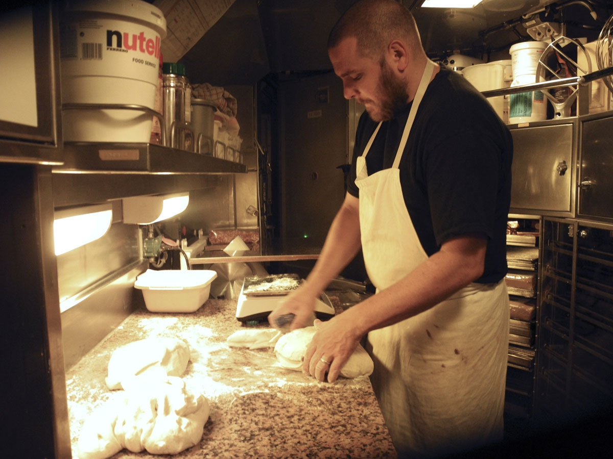This photo taken on October, 2016 off the coast of Brest aboard the French Navy's Triumphant-class strategic nuclear submarine Le Vigilant, shows the submarine's baker kneading bread and pastry dough.
