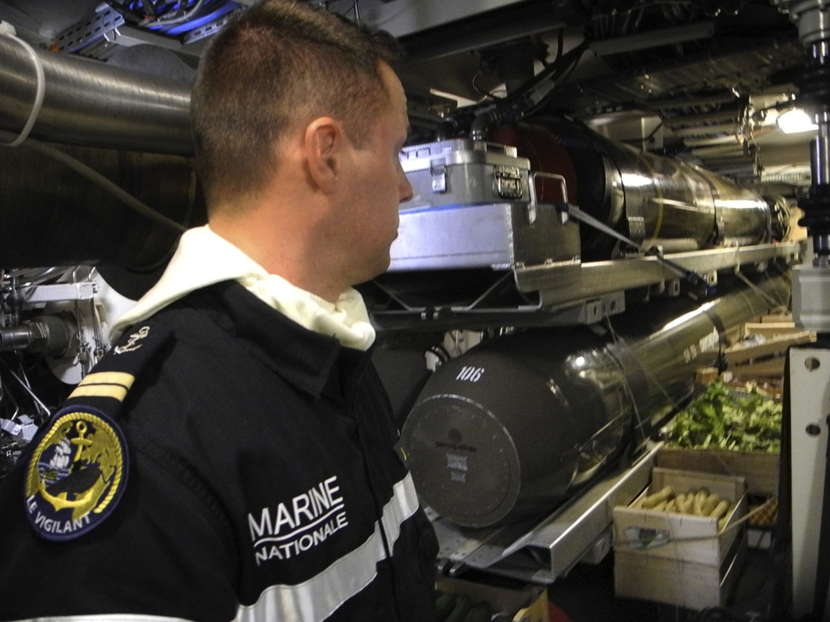 This photo taken on October, 2016 off the coast of Brest aboard the French Navy's Triumphant-class strategic nuclear submarine Le Vigilant, shows a sailor viewing crates of fruits and vegetables stored in the torpedos room.