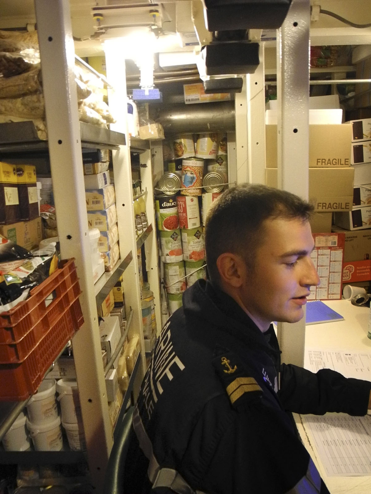 This photo taken on October, 2016 off the coast of Brest aboard the French Navy's Triumphant-class strategic nuclear submarine Le Vigilant, shows a petty officer checking the food stock in the goods storage room.