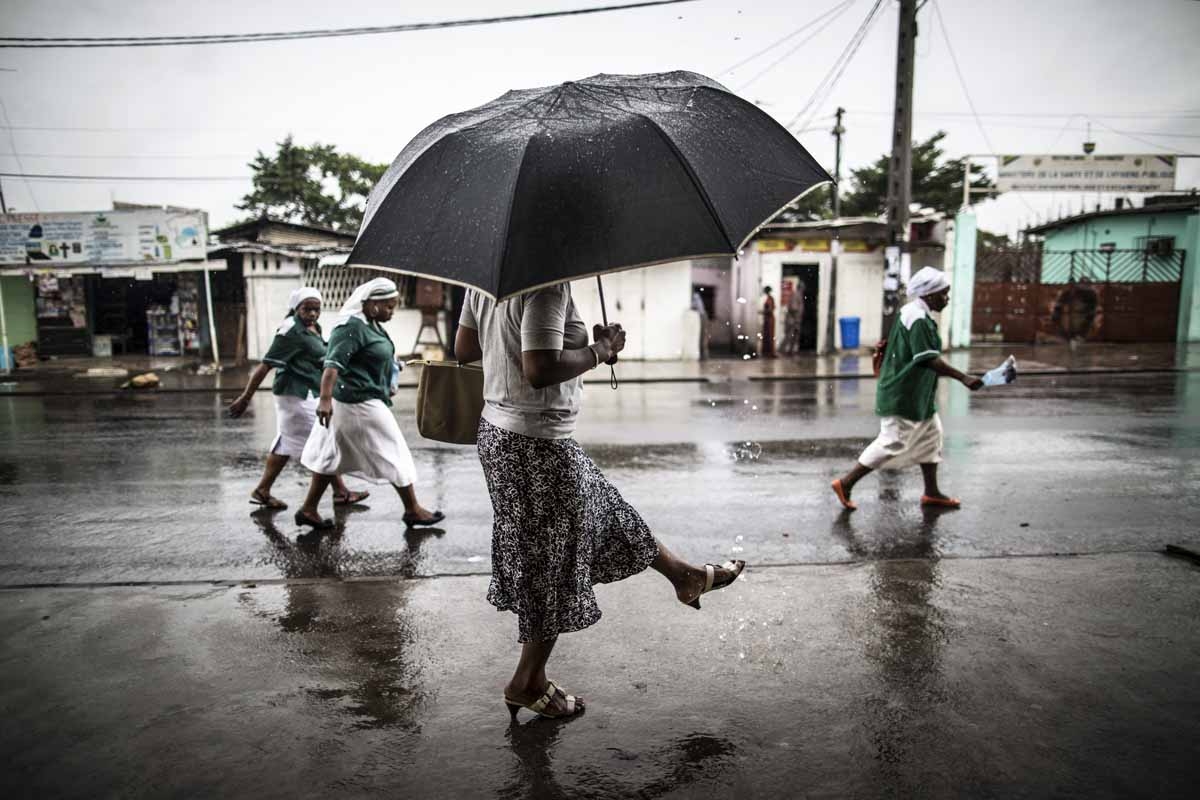 A woman washes a her foot with water streaming out of a pipe as catholic nuns leave the St. Michel Church in Libreville on August 28, 2016 after the Sunday's service. A woman washes a her foot with water streaming out of a pipe as catholic nuns leave the St. Michel Church in Libreville on August 28, 2016 after the Sunday's service.