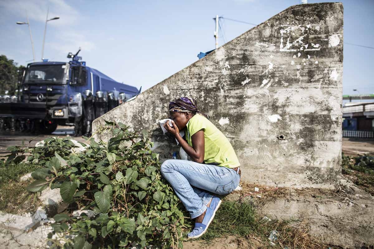 A Gabonese woman takes cover protecting her mouth from the tear gas as supporters of opposition leader Jean Ping protest, trying to reach the electoral commission, in Libreville on August 31, 2016. A Gabonese woman takes cover protecting her mouth from the tear gas as supporters of opposition leader Jean Ping protest, trying to reach the electoral commission, in Libreville on August 31, 2016.