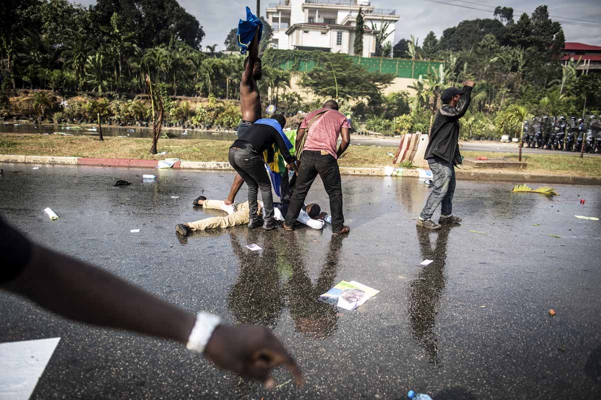 A supporter of Gabonese opposition leader Jean Ping lies on the ground in Libreville on August 31, 2016, during clashes with riot police as part of a protest sparked after Gabon's president Ali Bongo was declared winner of last weekend's contested electio A supporter of Gabonese opposition leader Jean Ping lies on the ground in Libreville on August 31, 2016, during clashes with riot police as part of a protest sparked after Gabon's president Ali Bongo was declared winner of last weekend's contested electio