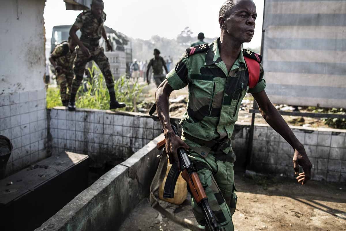 A Gabonese soldier runs to take position as supporters of opposition leader Jean Ping protest in front of security forces blocking the demonstration trying to reach the electoral commission, in Libreville on August 31, 2016, as part of a protest sparked a A Gabonese soldier runs to take position as supporters of opposition leader Jean Ping protest in front of security forces blocking the demonstration trying to reach the electoral commission, in Libreville on August 31, 2016, as part of a protest sparked a
