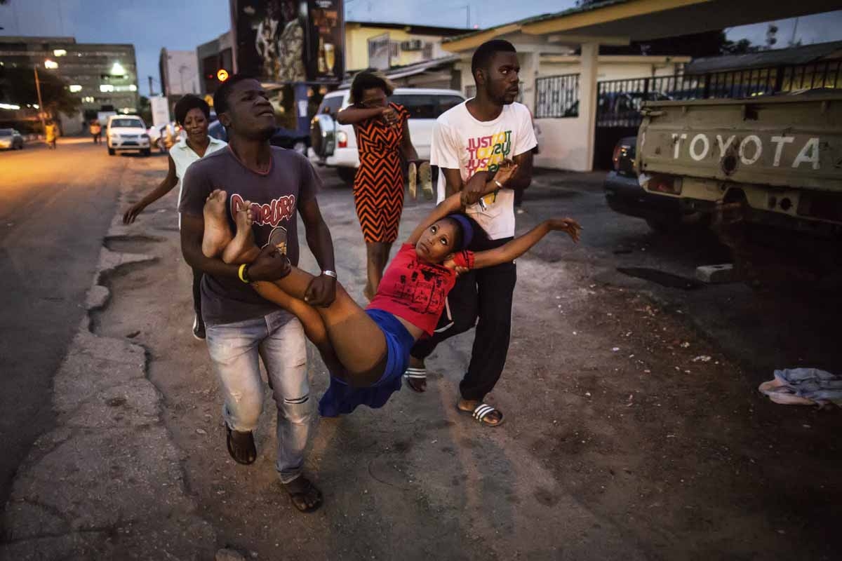 A relative a man detained during clashes is carried to the hospital after she fainted on September 1, 2016 in Libreville. A relative a man detained during clashes is carried to the hospital after she fainted on September 1, 2016 in Libreville.