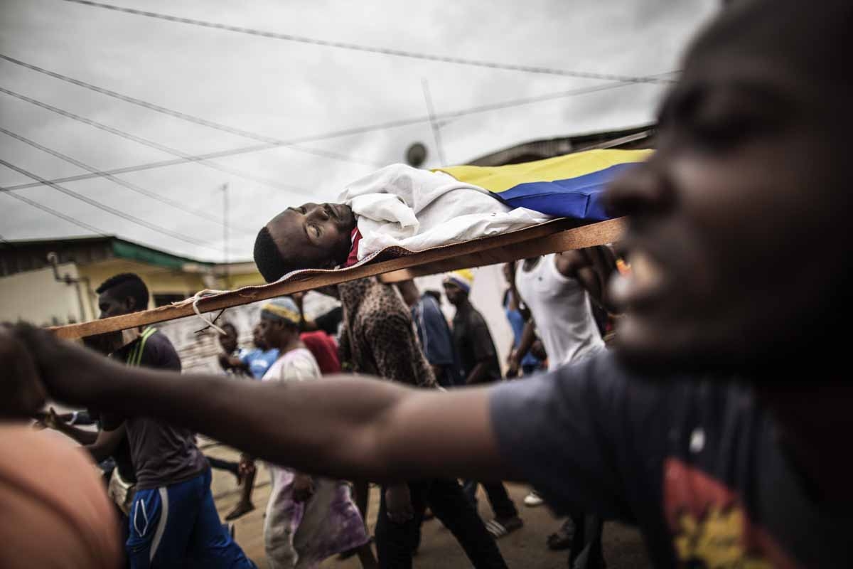 Dozens of protesters carry in a funeral procession the body of Axel Messa, 30, wrapped in the flag of Gabon, in a street of the Libreville district of Nzeng Ayong on September 2, 2016. His mother told AFP he was shot in front of his home on September 1, 2 Dozens of protesters carry in a funeral procession the body of Axel Messa, 30, wrapped in the flag of Gabon, in a street of the Libreville district of Nzeng Ayong on September 2, 2016. His mother told AFP he was shot in front of his home on September 1, 2