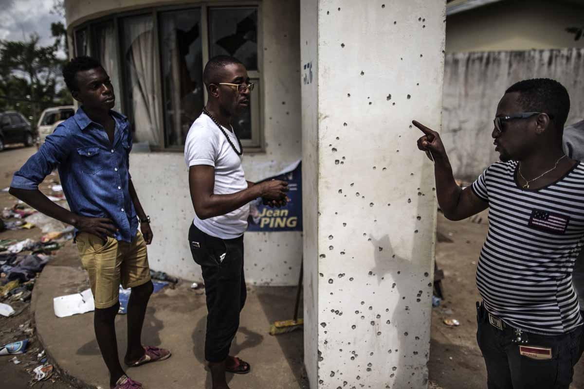 A man points out bullet holes at Gabon's opposition leader Jean Ping's headquarters on September 3, 2016 in Libreville. A man points out bullet holes at Gabon's opposition leader Jean Ping's headquarters on September 3, 2016 in Libreville.