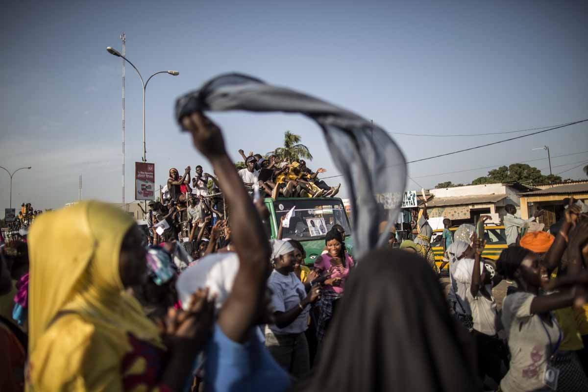 Supporters of Adama Barrow, the flag-bearer of the coalition of the seven opposition political parties in Gambia, gather in the streets of Talinding on the outskirts of Banjul on November 25, 2016 to try to catch a glimpse of the candidate motorcade trans