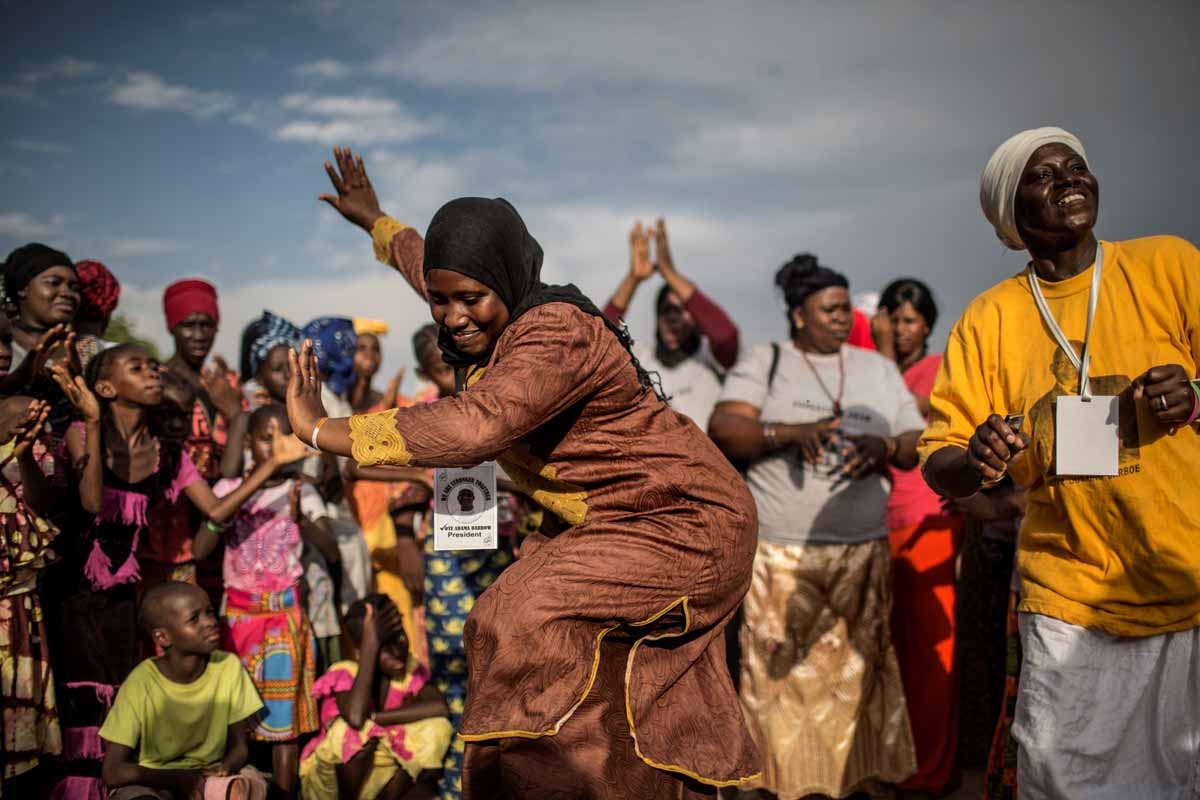 Supporters of Adama Barrow, the flag-bearer of the coalition of the seven opposition political parties in Gambia dance at the venue of a political rally in Wellingara on November 28, 2016.