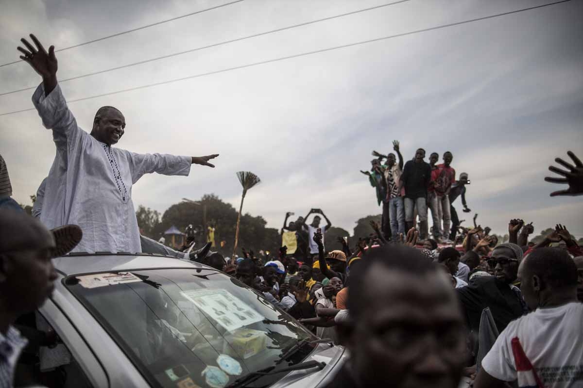 Adama Barrow, the flag-bearer of the coalition of the seven opposition political parties in Gambia, greets supporters from the roof of his car at a gathering in the buffer Zone district of Talinding on November 29, 2016 on the last day of the presidential