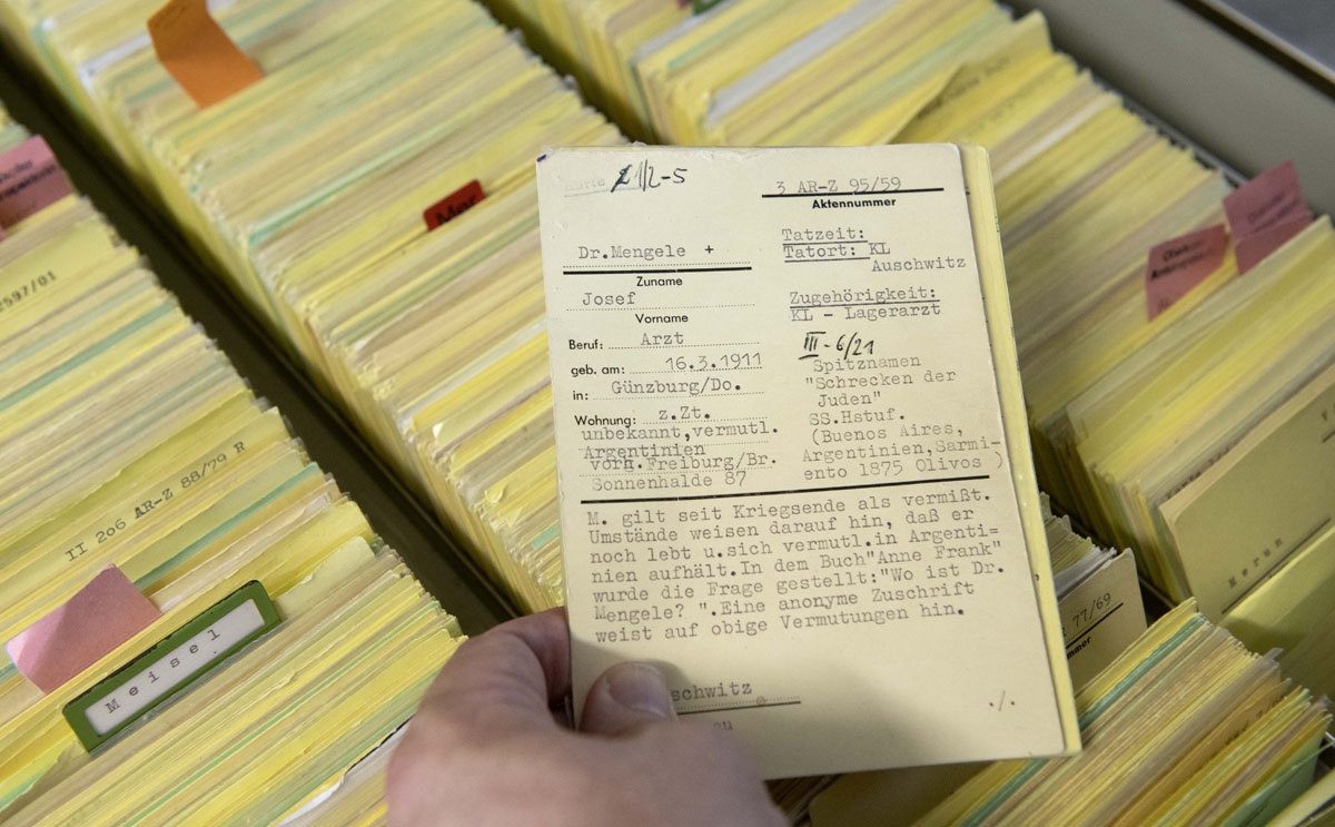 German prosecutor, head of Central Office of the Judicial Authorities of the Federal States for the Investigation of National Socialist Crimes, Jens Rommel shows an index card bearing the name of former physician Josef Mengele in the archives room of the