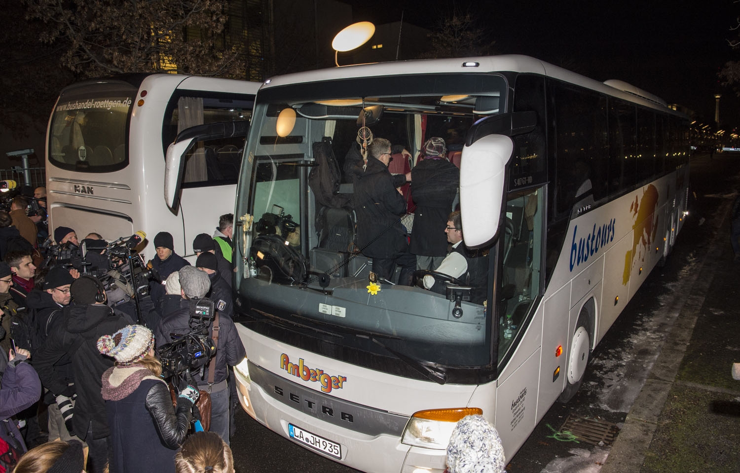 Reporters surround a bus carrying refugees parked in front of the chancellery in Berlin on January 14, 2016, after it arrived from the Bavarian city of Landshut. Reporters surround a bus carrying refugees parked in front of the chancellery in Berlin on January 14, 2016, after it arrived from the Bavarian city of Landshut.
