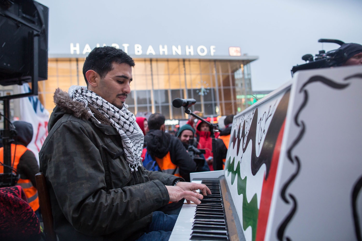Syrian-Palestinian pianist Aeham Ahmad plays the piano during a demonstration of Syrian refugees against violence on January 16, 2016 in Cologne, western Germany Syrian-Palestinian pianist Aeham Ahmad plays the piano during a demonstration of Syrian refugees against violence on January 16, 2016 in Cologne, western Germany