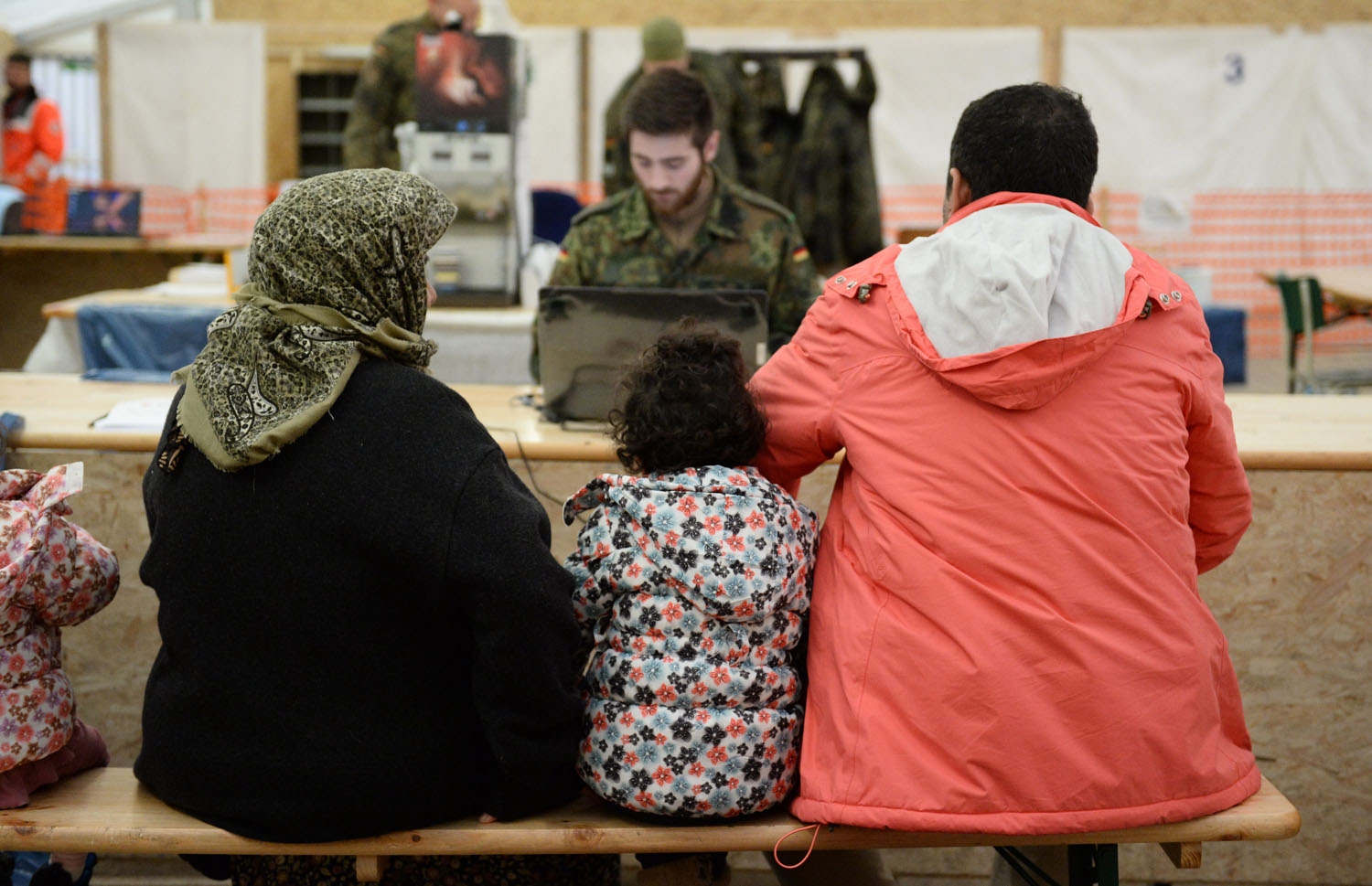 Refugees from Syria wait to register at the German army's air base in Erding, southern Germany, on January 31, 2016 Refugees from Syria wait to register at the German army's air base in Erding, southern Germany, on January 31, 2016