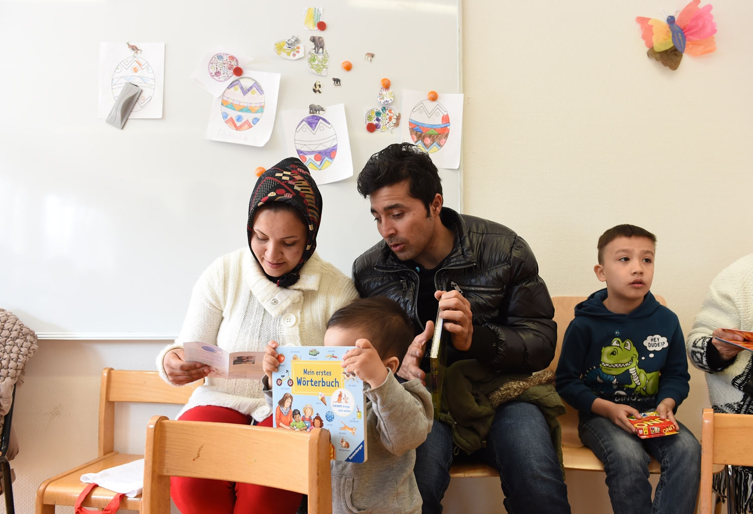 Refugee children and their parents from Afghanistan look at books and games during a first event of the three-year program reading start for refugee children in the refugee camp Bayernkaserne in Munich, southern Germany, on March 21, 2016 Refugee children and their parents from Afghanistan look at books and games during a first event of the three-year program reading start for refugee children in the refugee camp Bayernkaserne in Munich, southern Germany, on March 21, 2016