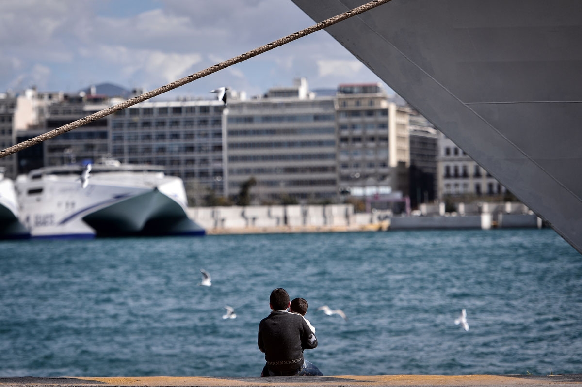hildren sit in the port of Piraeus on March 10, 2016, as they wait with other migrants and refugees to be transferred to a refugee camp in central Greece.
