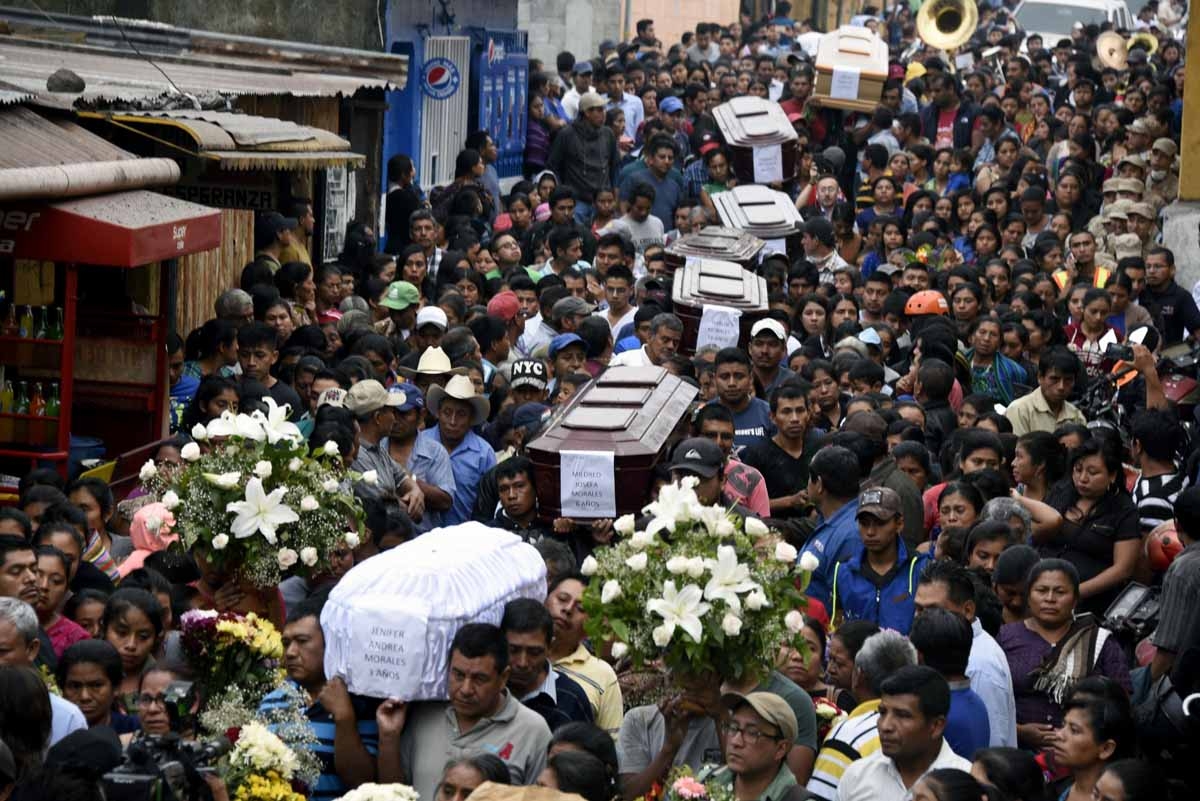 People carries the coffins of seven people who died following the eruption of the Fuego volcano, at the streets of Alotenango municipality, Sacatepequez, about 65 km southwest of Guatemala City, on June 4, 2018. Rescue workers Monday pulled more bodies fr