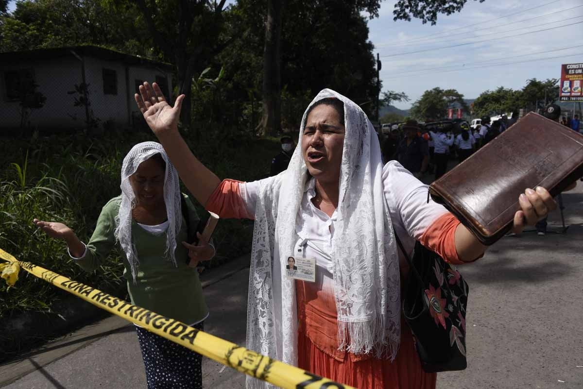 Two women praying at the entrance to the disaster zone in village of San Miguel Los Lotes, in Escuintla Department, about 35 km southwest of Guatemala City, on June 6, 2018. Nearly 200 people are missing and at least 75 have been killed since Guatemala's