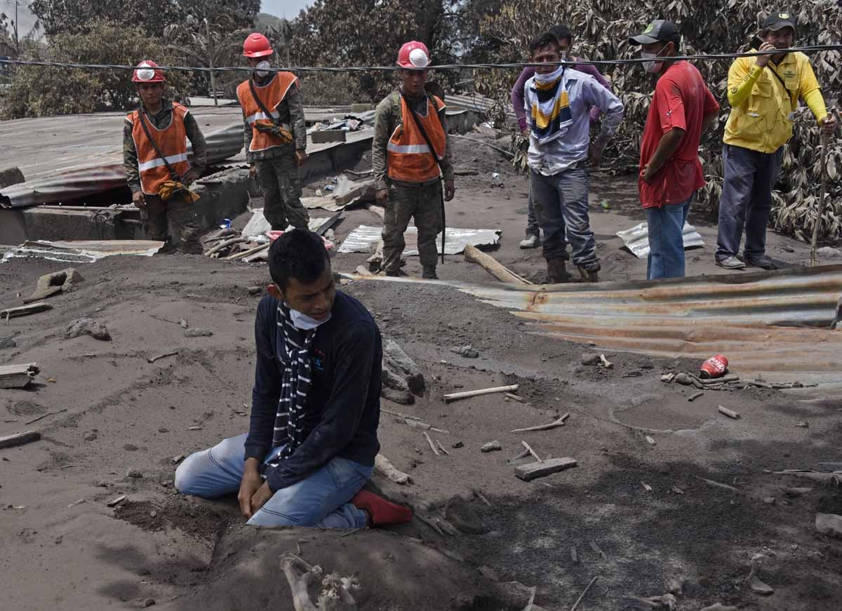 Bryan Rivera 22 year-odl cries during search relatives victims of the Fuego Volcano eruption in the ash-covered village of San Miguel Los Lotes, in Escuintla Department, about 35 km southwest of Guatemala City, on June 7, 2018. Nearly 200 people are missi