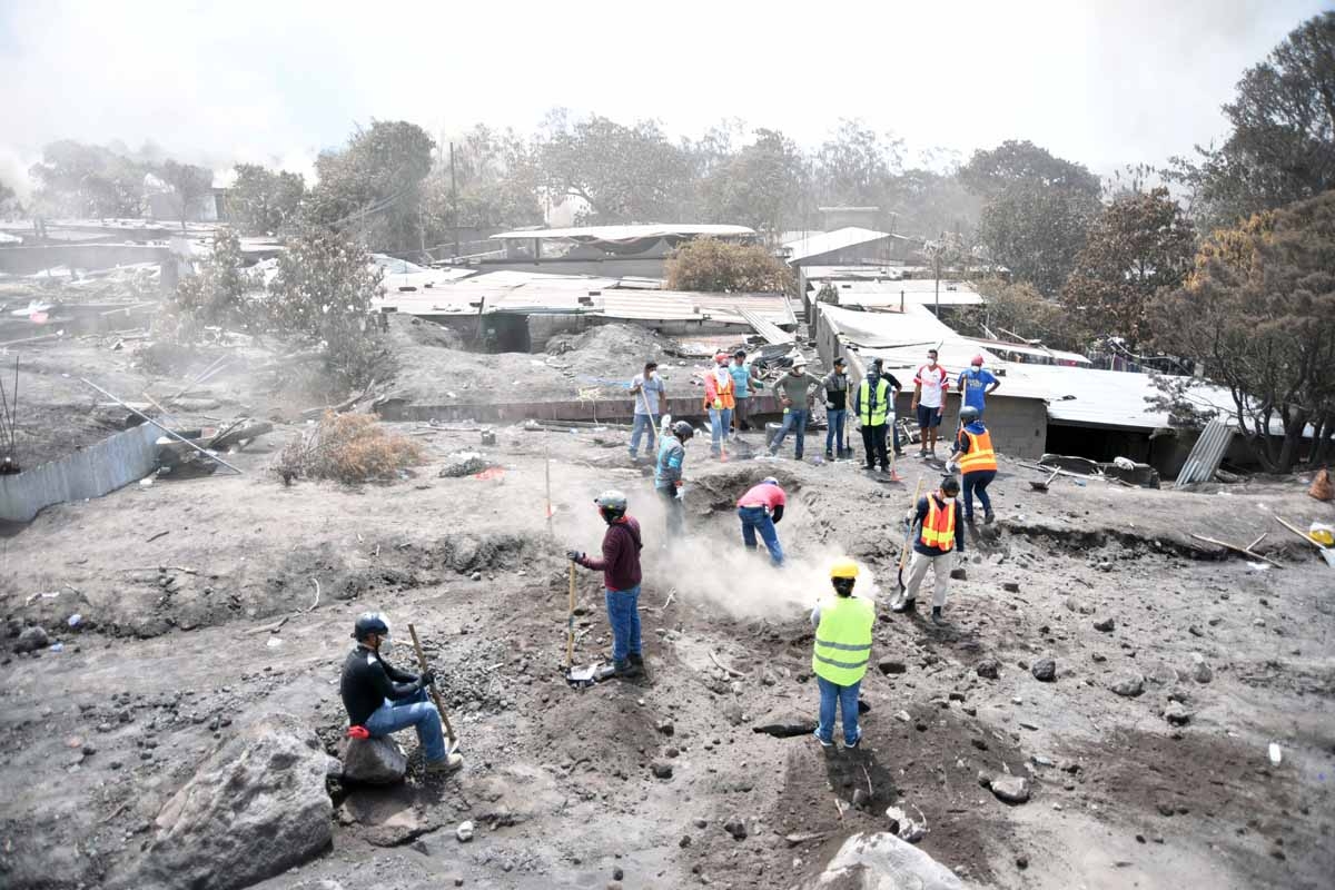 Resident take part in the search for victims of the Fuego Volcano, in the ash-covered village of San Miguel Los Lotes, in Escuintla department, about 35 km southwest of Guatemala City, on June 9, 2018. The threat of fresh landslides forced emergency worke