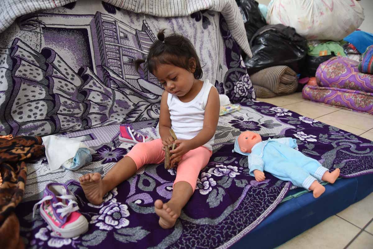 A girl plays in a temporary shelter in Escuintla department, 35 km south of Guatemala City on June 9, 2018. The threat of fresh landslides forced emergency workers Thursday to suspend a search for victims of a major eruption of Guatemala's Fuego Volcano, 