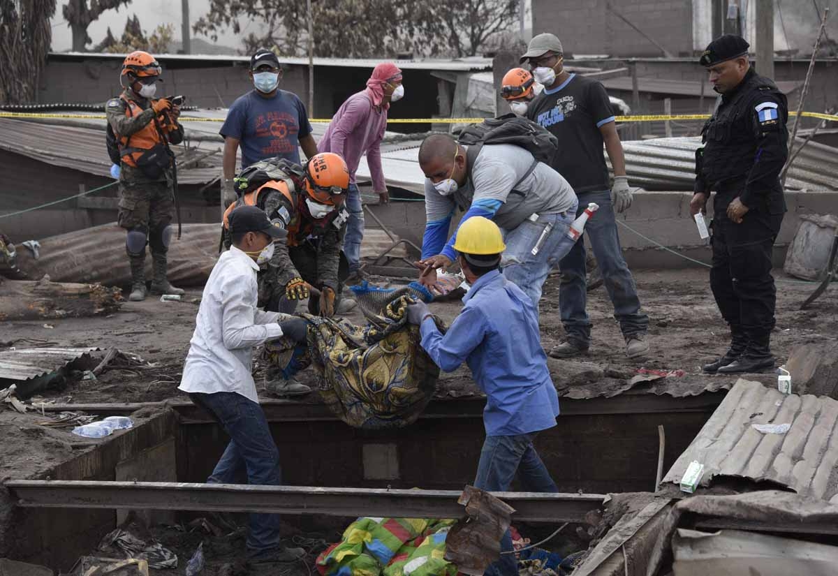 Rescuers carries part of the body of a victim of the Fuego Volcano eruption, recovered during a search in the ash-covered village of San Miguel Los Lotes, in Escuintla department, about 35 km southwest of Guatemala City, on June11, 2018. A week after Guat