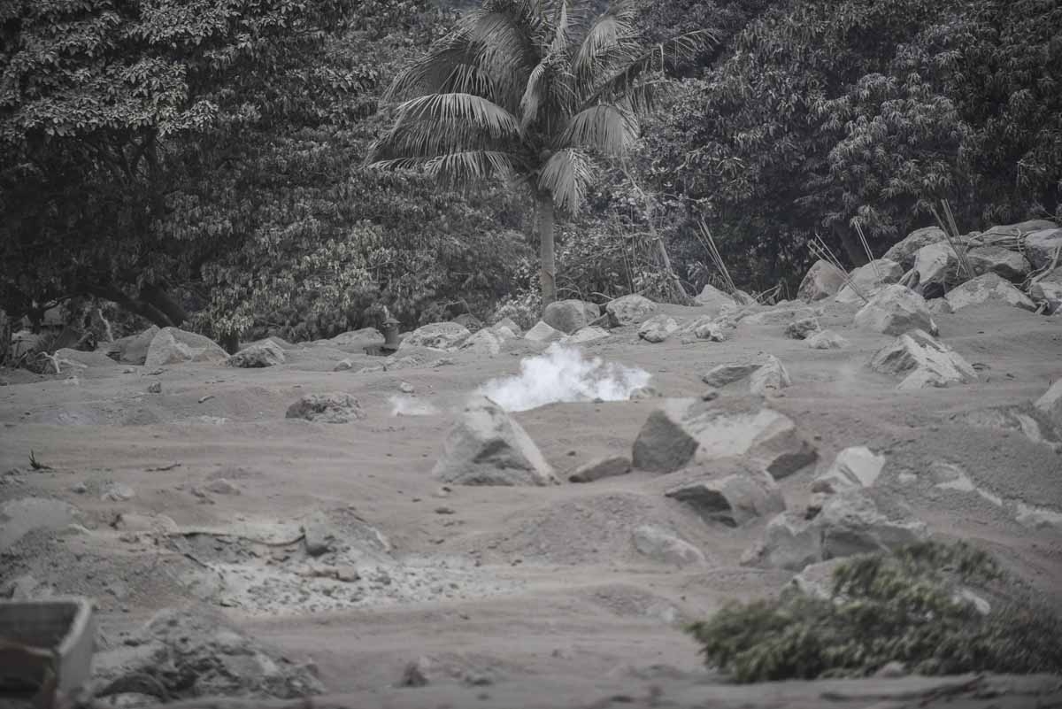 Smoke billows from the ashes in San Miguel Los Lotes, a village in Escuintla Department, about 35 km southwest of Guatemala City, on June 4, 2018, a day after the eruption of the Fuego Volcano. At least 25 people were killed, according to the National Coo