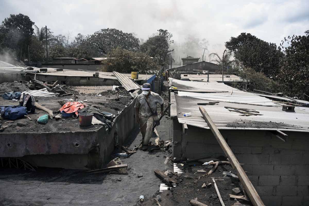 Residents search relatives victims of the Fuego Volcano eruption in the ash-covered village of San Miguel Los Lotes, in Escuintla Department, about 35 km southwest of Guatemala City, on June 7, 2018. Nearly 200 people are missing and at least 99 have been