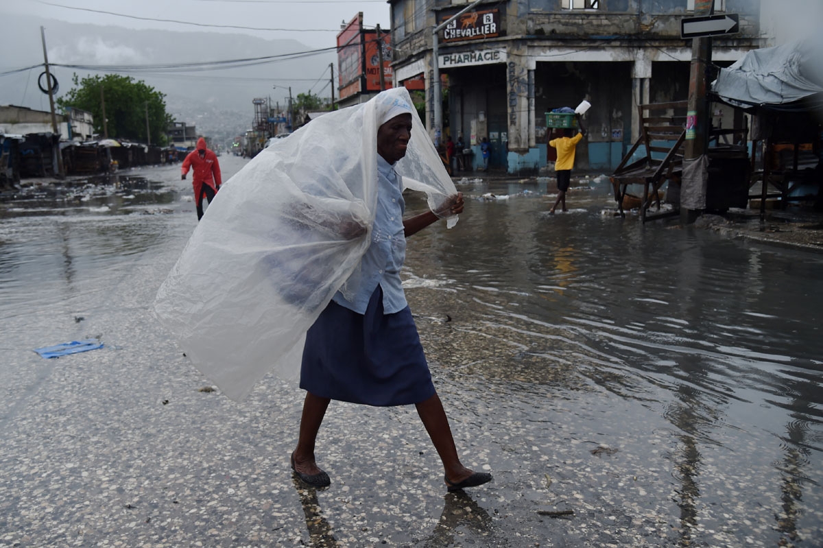 A woman protects herself from the rain with plastic after hurricane Matthew, in Port-au-Prince, on October 4, 2016. A woman protects herself from the rain with plastic after hurricane Matthew, in Port-au-Prince, on October 4, 2016.