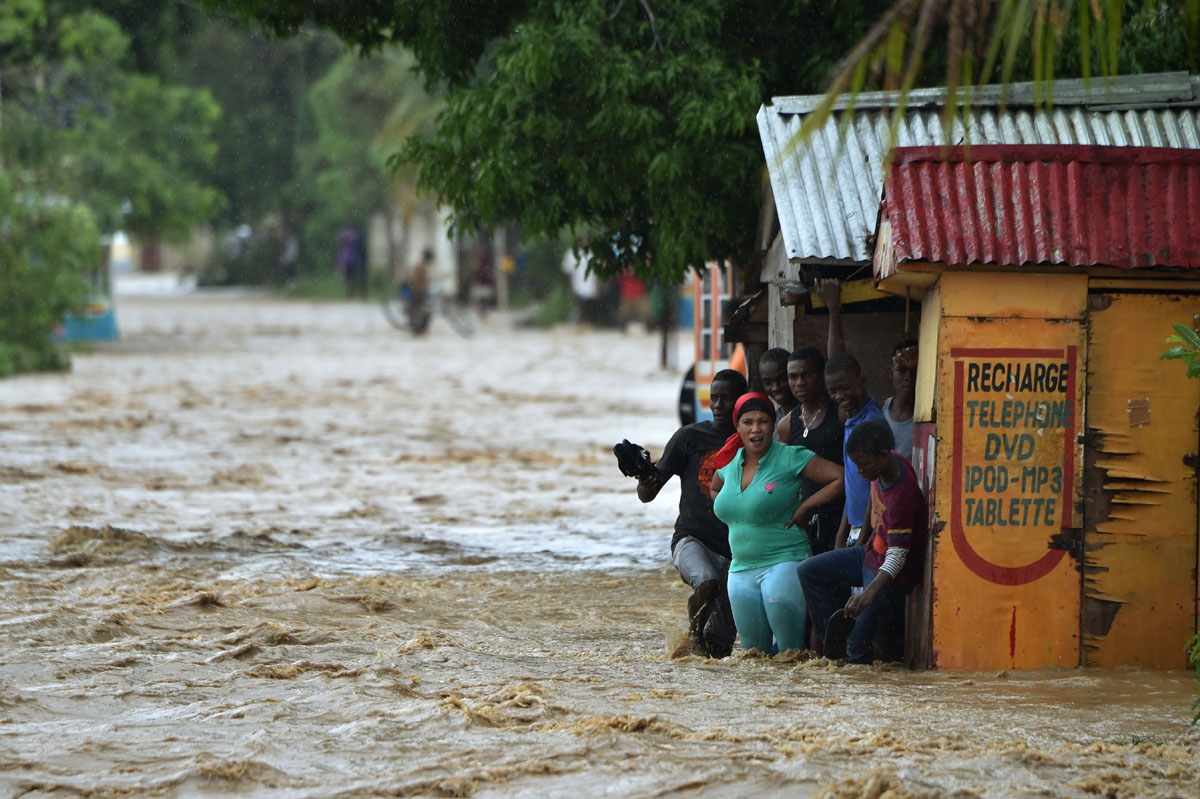 People try to cross the overflowing La Rouyonne river in the commune of Leogane, south of Port-au-Prince, October 5, 2016. People try to cross the overflowing La Rouyonne river in the commune of Leogane, south of Port-au-Prince, October 5, 2016.