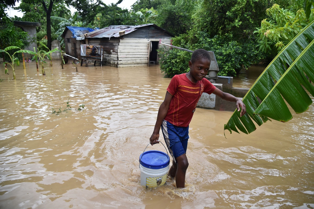 Jonnathan fetches clean water for his mother cleaning his home flooded by the overflowing of the La Rouyonne river in the commune of Leogane, south of Port-au-Prince, October 5, 2016. Jonnathan fetches clean water for his mother cleaning his home flooded by the overflowing of the La Rouyonne river in the commune of Leogane, south of Port-au-Prince, October 5, 2016.