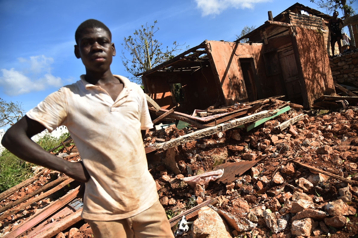 A young man stands in front of a home destroyed by Hurricane Matthew in the small village of Casanette, Haiti, on October 8, 2016. A young man stands in front of a home destroyed by Hurricane Matthew in the small village of Casanette, Haiti, on October 8, 2016.