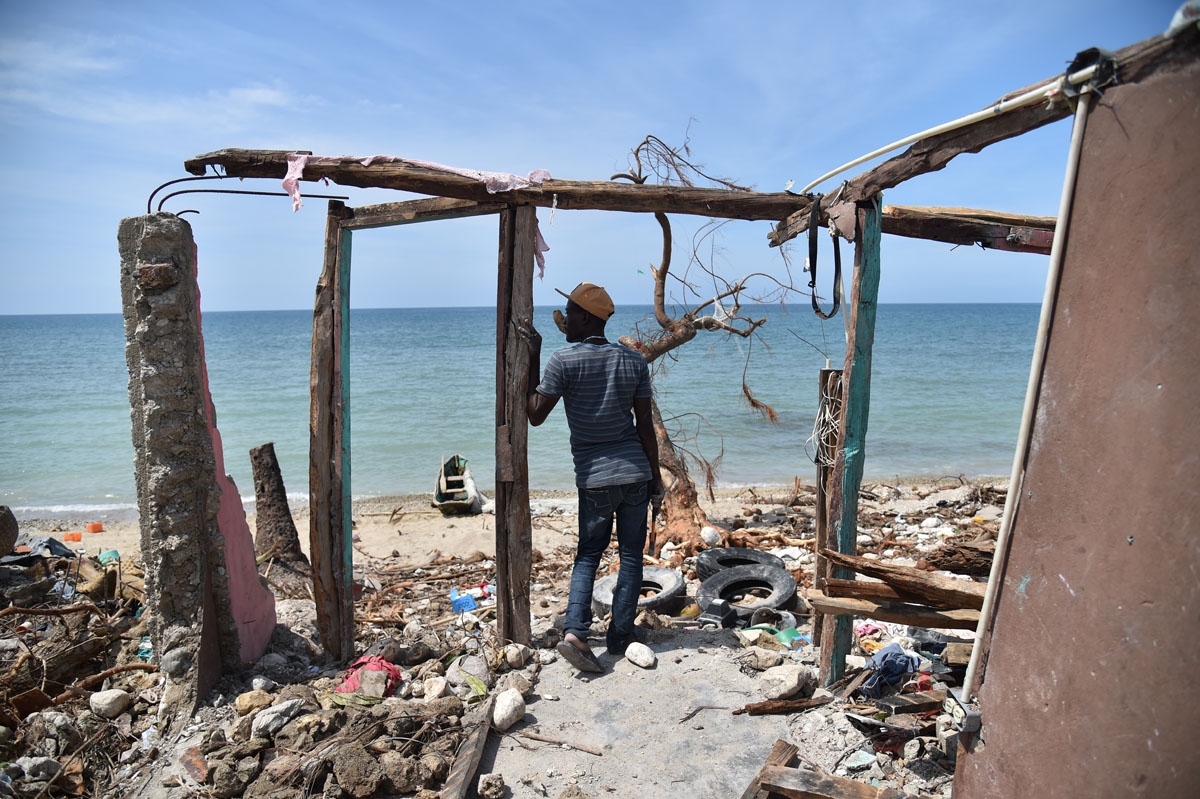 A man stands next to a destroyed house in Les Cayes, Haiti on October 10, 2016, following the passage of Hurricane Matthew. A man stands next to a destroyed house in Les Cayes, Haiti on October 10, 2016, following the passage of Hurricane Matthew.