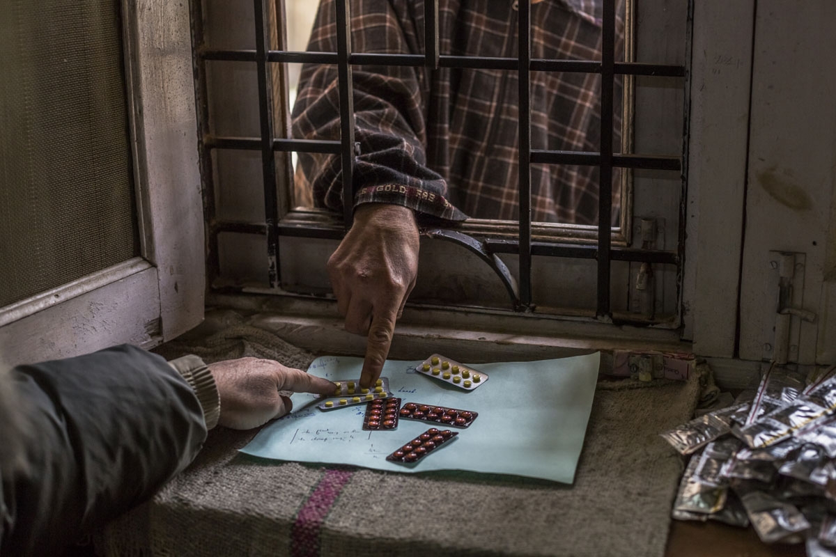 In this photo taken on December 4, 2015, a Kashmiri patient suffering from symptoms of depression reaches through a barred window to collect a repeat prescription for range of anti-depressants at the dispensary at the Psychiatric Diseases government hospi