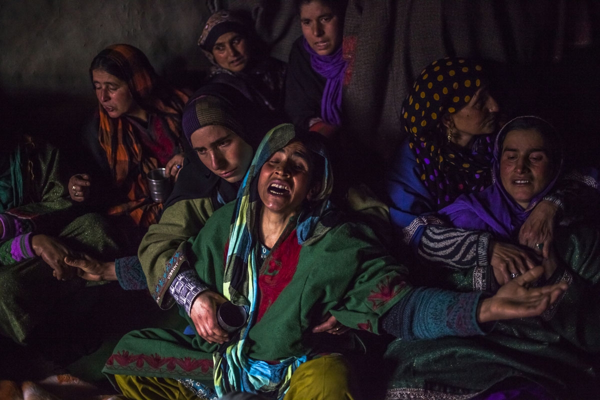 In this photo taken on December 14, 2015, Kashmiri relative Hafeeza Khan (C) weeps during the funeral of nephew Rasiq Ahmed Khan, aged around 22, and who was found shot to death, at their home in Watchohallan village in south Kashmir's Shopian district so