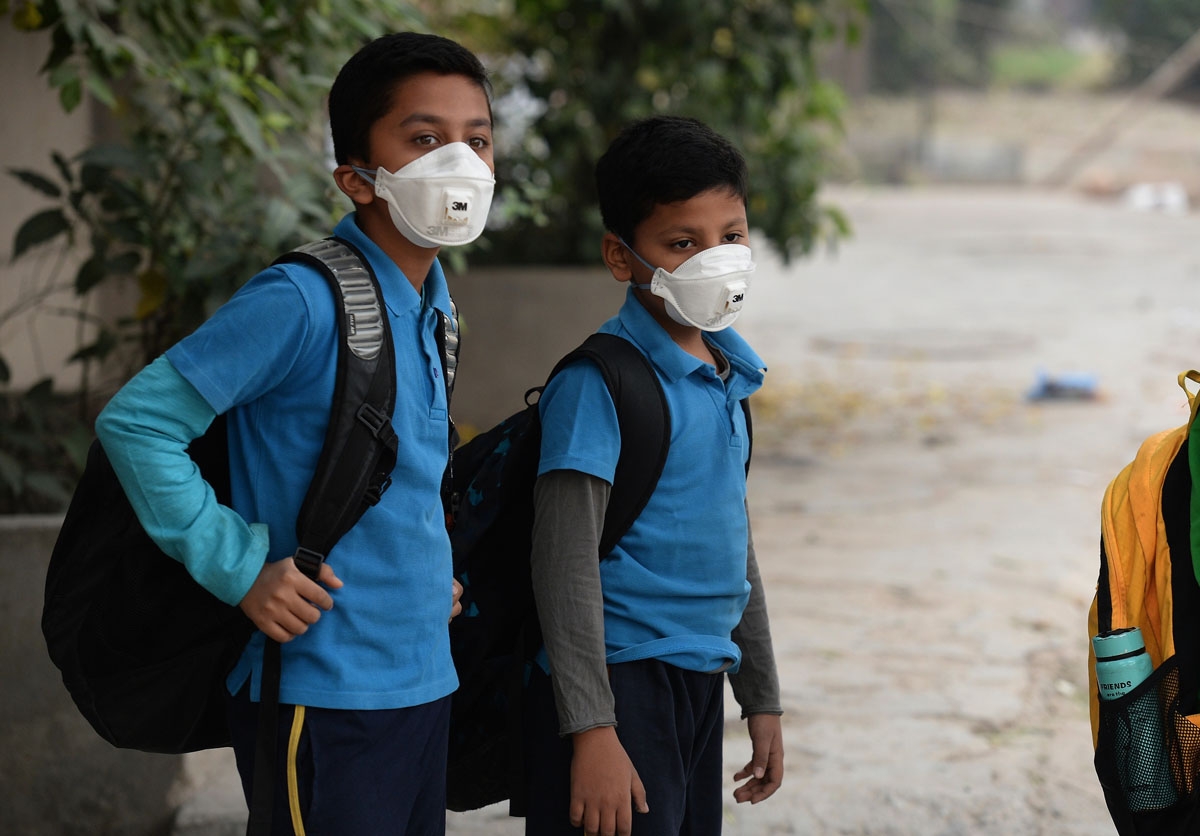 Indian school children wear masks as they wait for the bus as schools re-open after three days of closure due to smog, in New Delhi on November 10, 2016. / AFP PHOTO / PRAKASH SINGH Indian school children wear masks as they wait for the bus as schools re-open after three days of closure due to smog, in New Delhi on November 10, 2016. / AFP PHOTO / PRAKASH SINGH