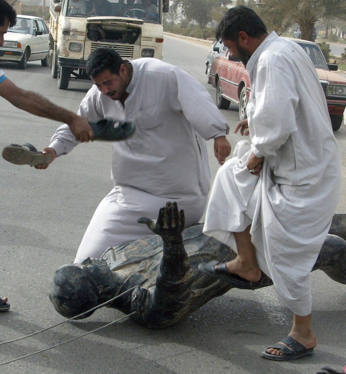 Iraqis hit and trample a statue of President Saddam Hussein in Baghdad 09 April 2003 after US tanks rolled into the heart of the Iraqi capital.