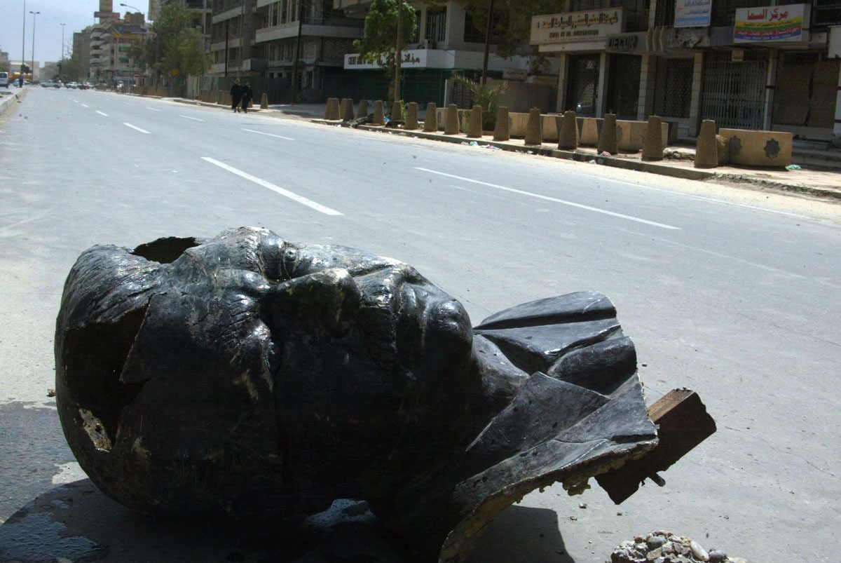 A shoe sits on a decapitated head of Saddam Hussein bronze statue in a Baghdad street10 April 2003, one day after the fall of the Iraqi leader's regime. AFP PHOTO/PATRICK BAZ / AFP PHOTO / PATRICK BAZ