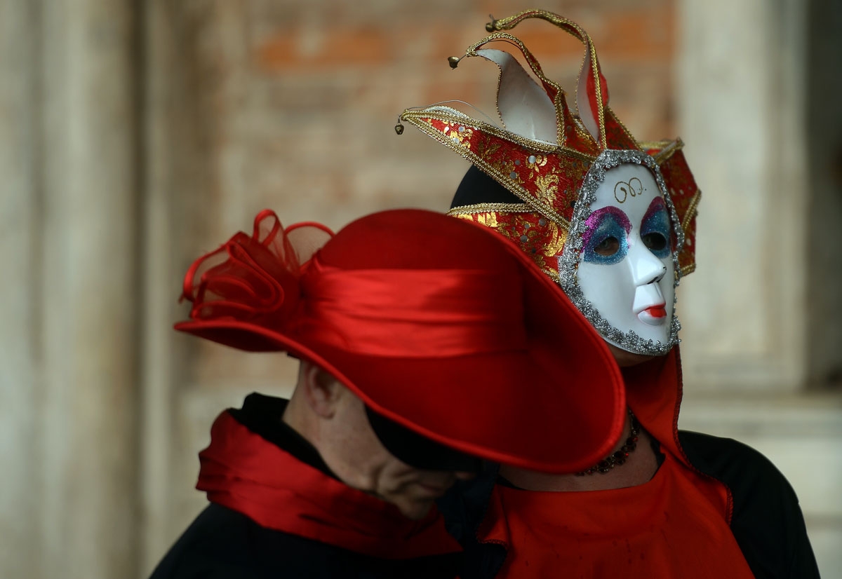Masked revellers wearing traditional carnival costumes stand in St Mark Square during Venice's Carnival on January 28, 2018. /