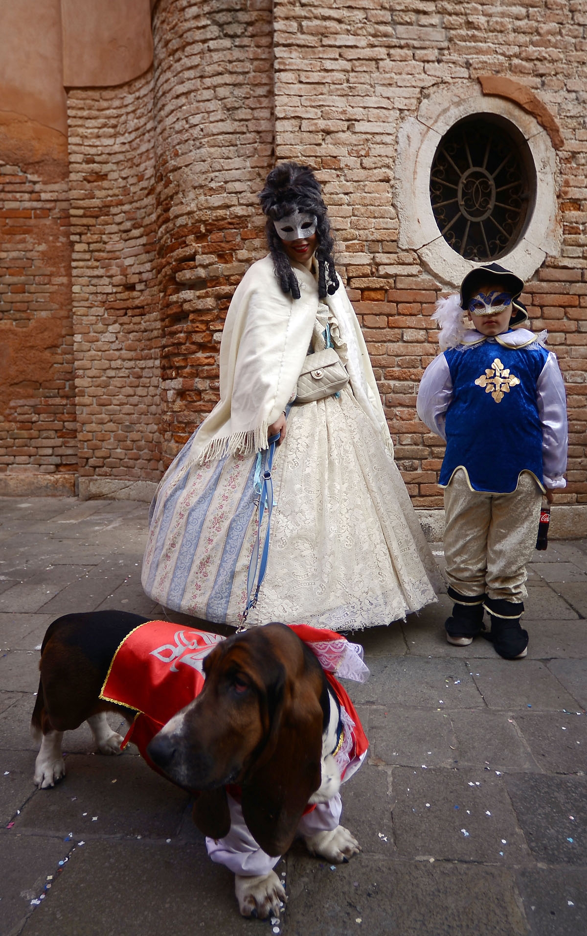 Masked revellers wearing traditional carnival costumes stand in St Mark Square during Venice's Carnival on January 28, 2018.