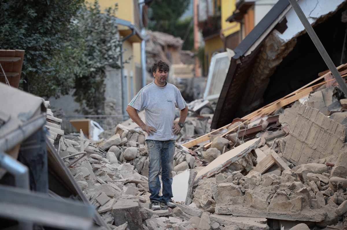A man stands on a damaged home after a strong earthquake hit Amatrice on August 24, 2016. A man stands on a damaged home after a strong earthquake hit Amatrice on August 24, 2016.