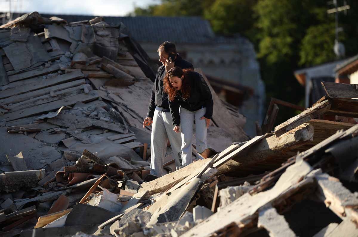 Residents stand among damaged buildings after a strong earthquake hit Amatrice on August 24, 2016. Residents stand among damaged buildings after a strong earthquake hit Amatrice on August 24, 2016.